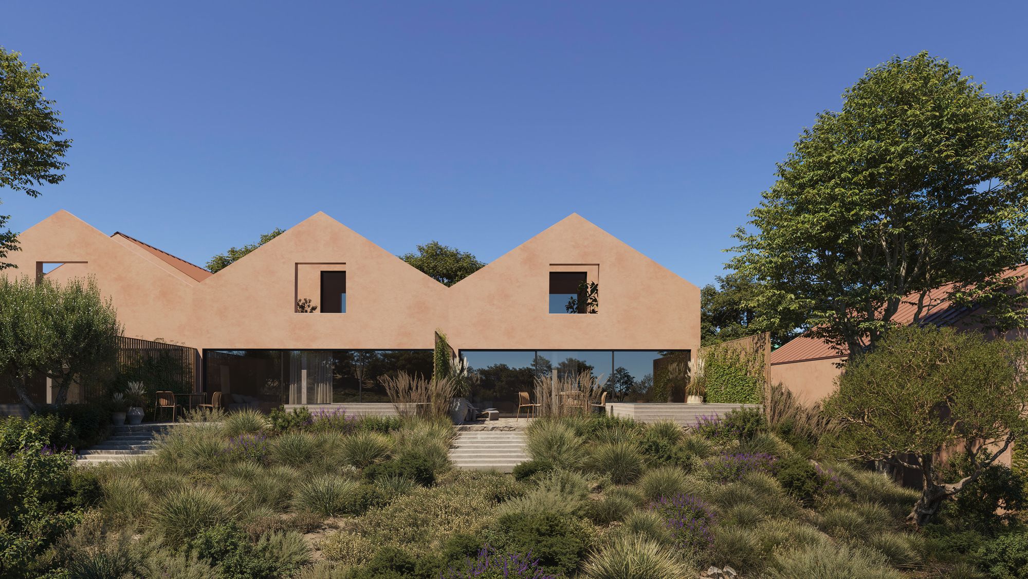Casa Horizonte from the garden with the glass wall of the living room open onto a terrace of grasses